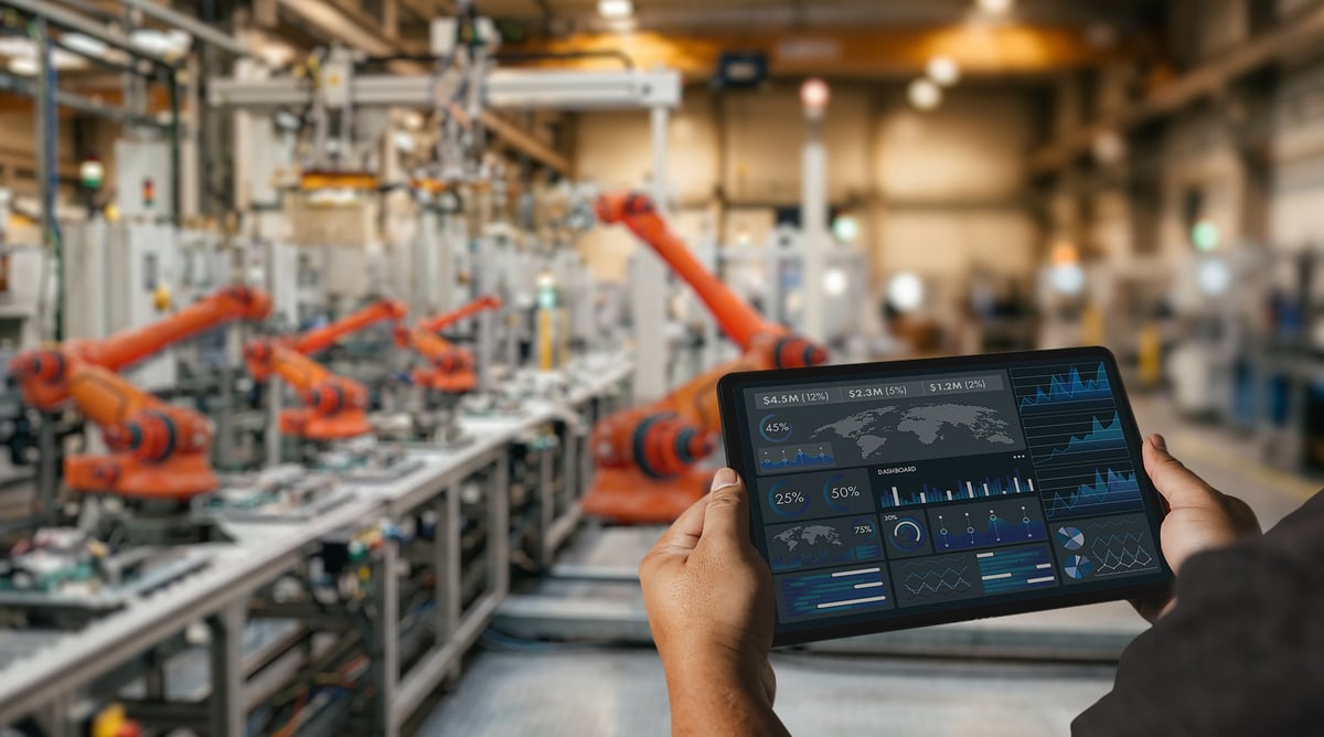 Ingeniero usando un panel en tableta dentro de una fábrica automatizada para monitoreo de producción industrial